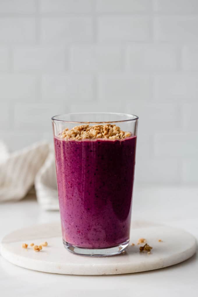a glass of acai smoothie on a marble board