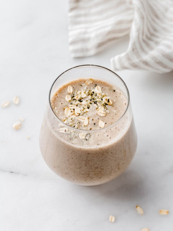 a banana bread smoothie in a glass on a marble counter