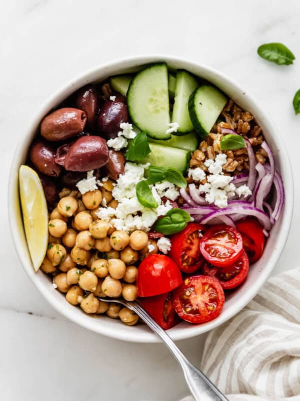 A greek power bowl with chickpeas, cherry tomatoes, olives and cucumber