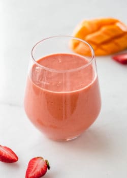a strawberry mango smoothie with strawberries on the side