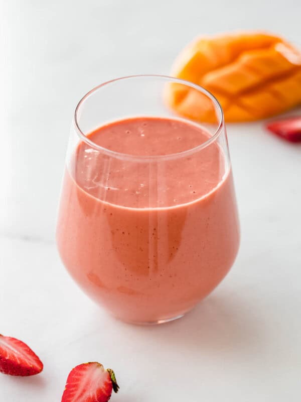 a strawberry mango smoothie with strawberries on the side