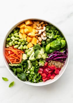 A bowl of chopped vegetables, mango, nuts and seeds