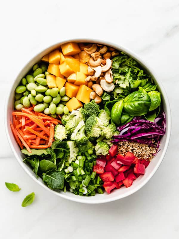 A bowl of chopped vegetables, mango, nuts and seeds