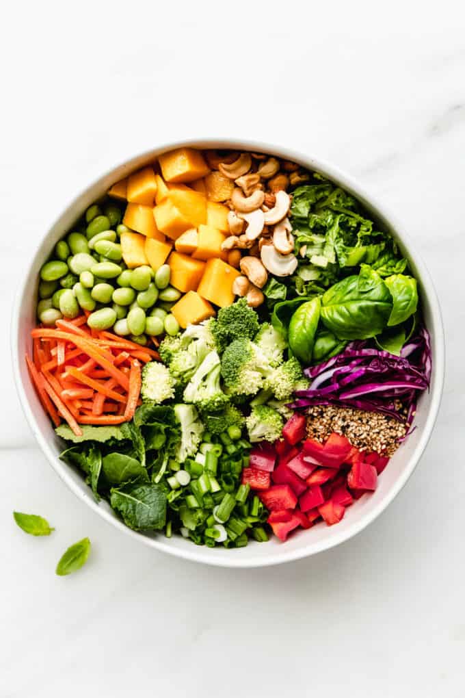 A bowl of chopped vegetables, mango, nuts and seeds