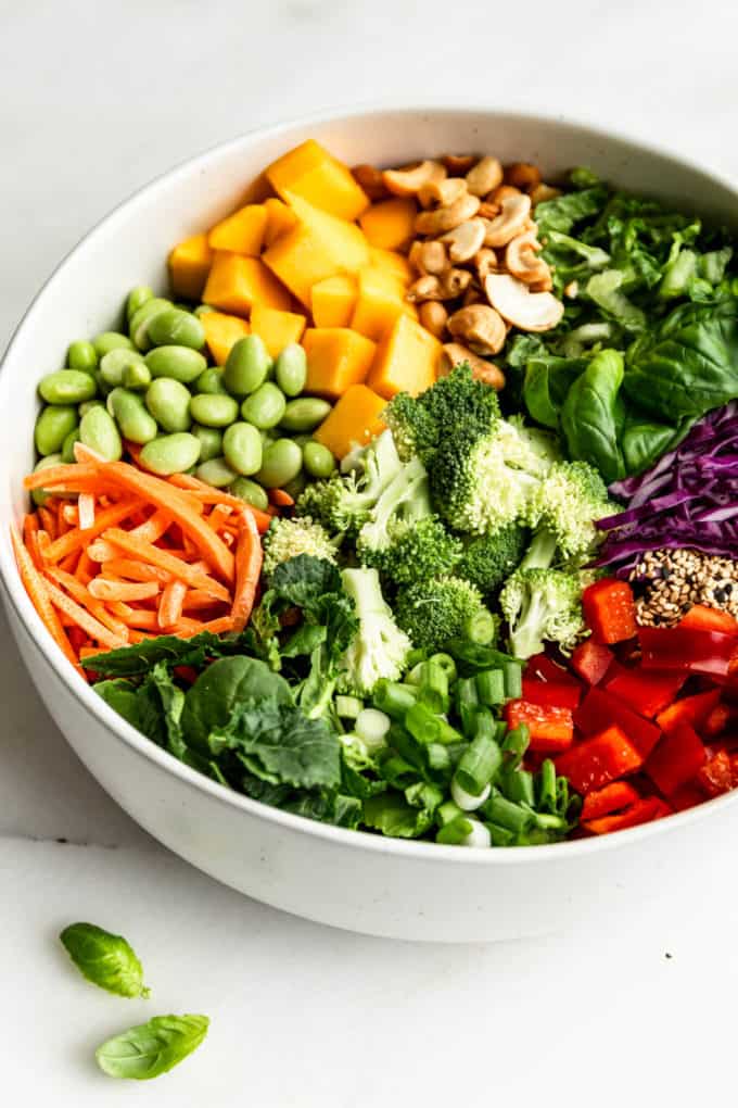 Thai Crunch Salad ingredients in a white serving bowl on a marble counter