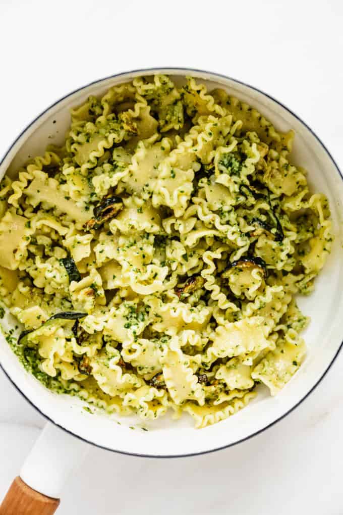 Noodles with pesto on them in a white pot