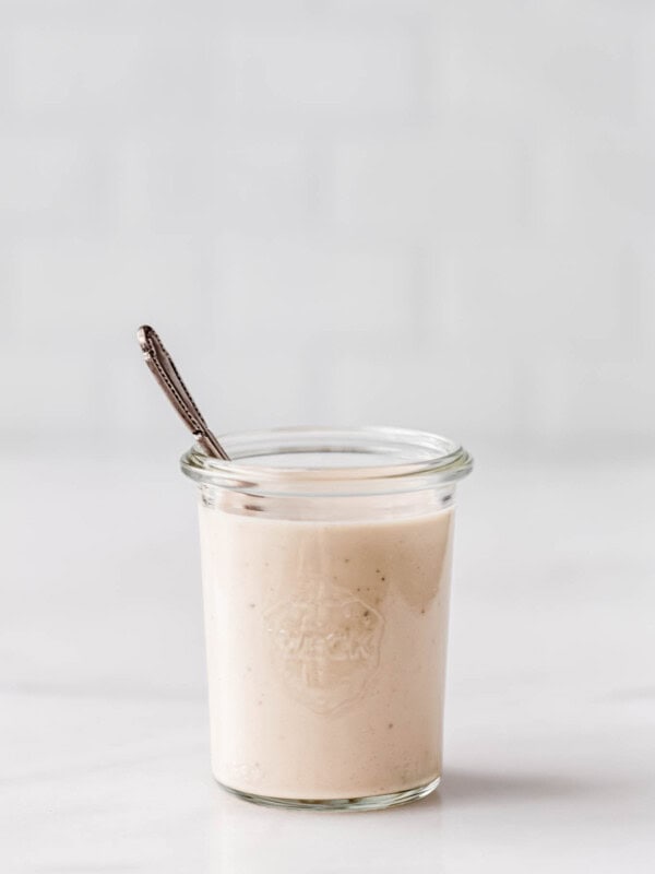 A small jar filled with lemon tahini dressing