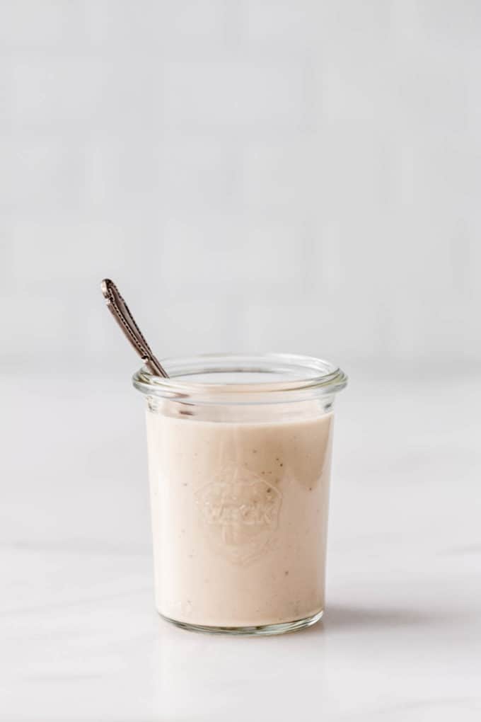 A small jar filled with lemon tahini dressing