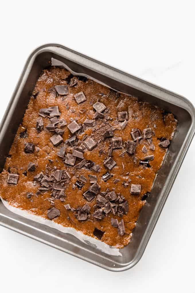 Unbaked almond butter blondies in an 8x8 inch pan