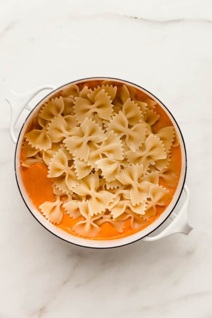 A white pot with vegan vodka sauce and farfalle pasta