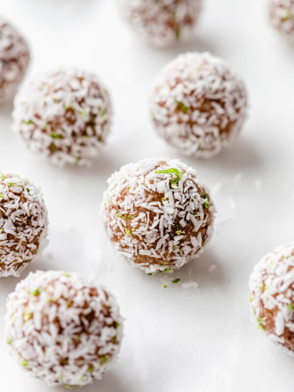 a key lime pie energy ball with shredded coconut and lime zest on it