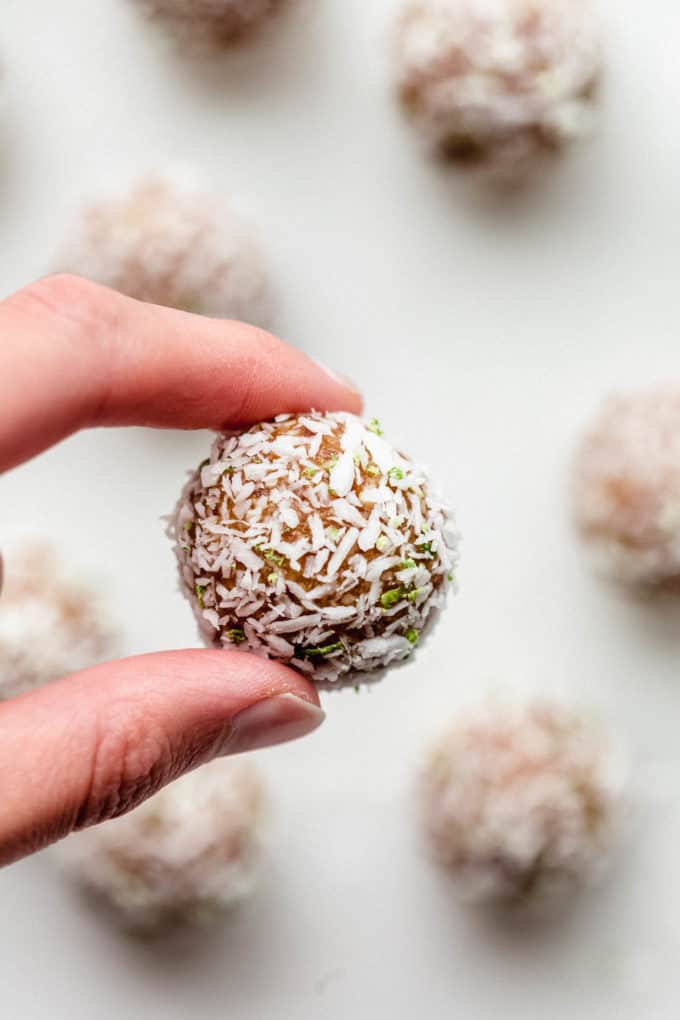 A hand holding a key lime energy ball