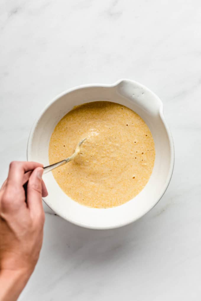 Cornbread batter in a white mixing bowl