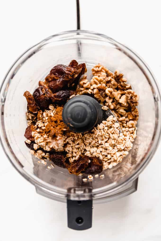 A food processor with dates, walnuts and oats in it
