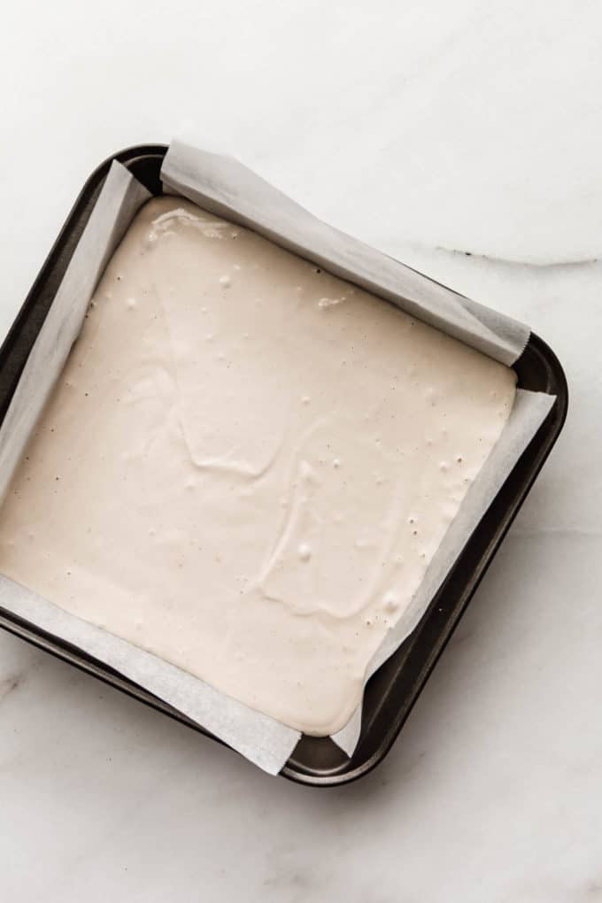 A baking pan with raw vegan cheesecake in it