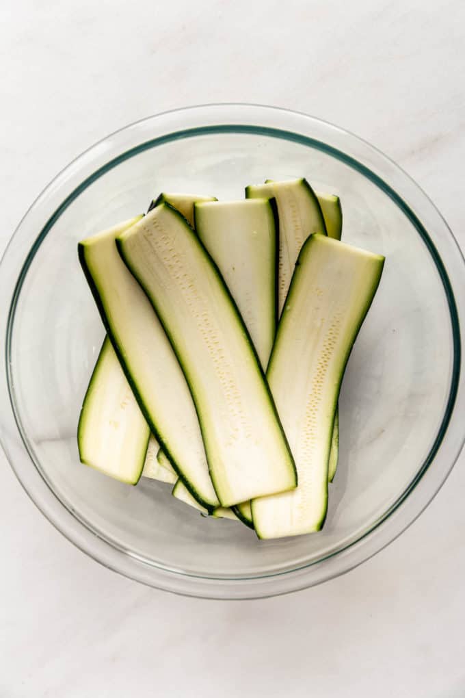 Slices of zucchini in a clear mixing bowl