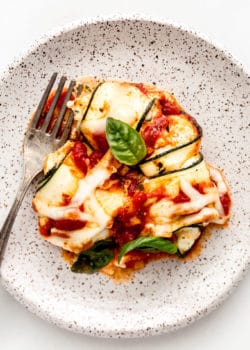 Zucchini involtini on a white speckled plate
