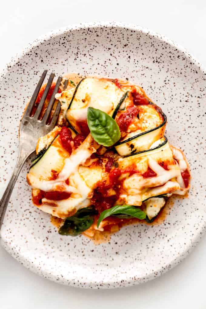 Zucchini involtini on a white speckled plate