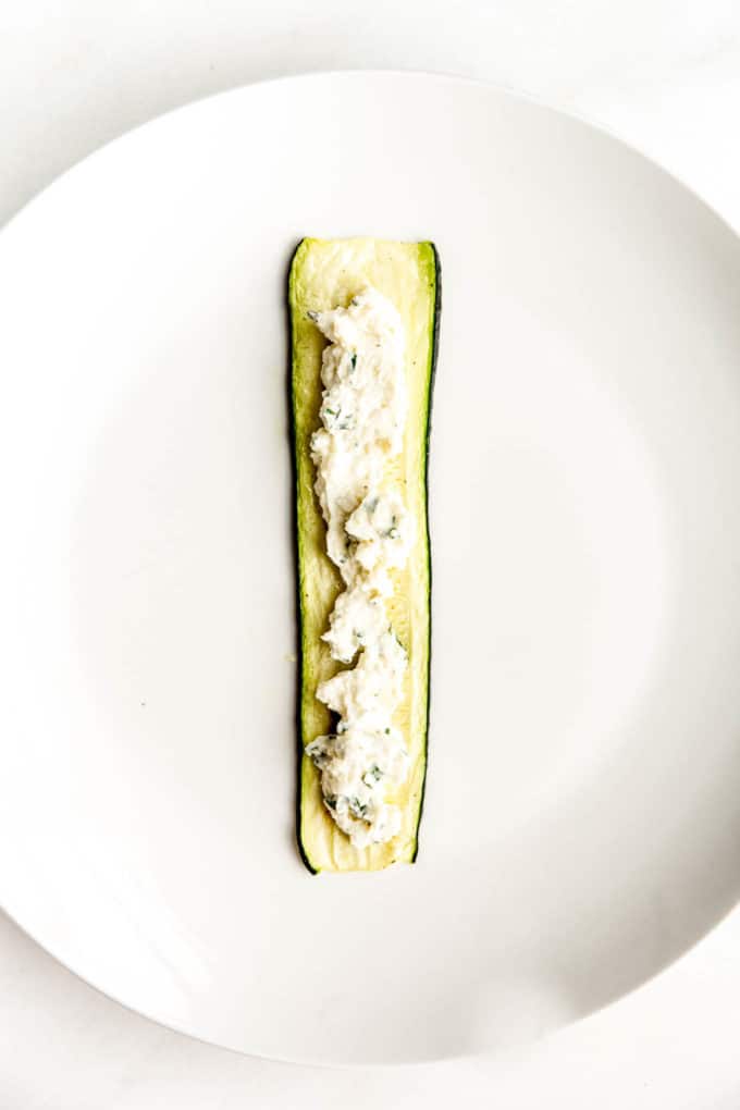 A slice of zucchini with ricotta spread in the centre
