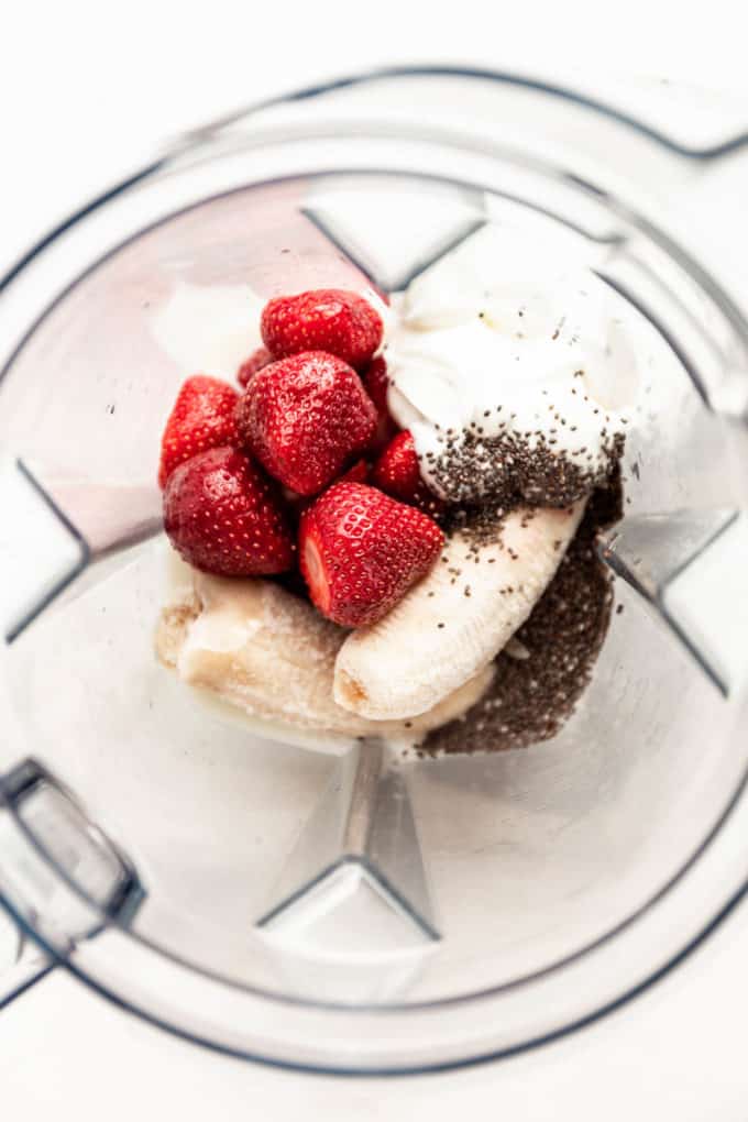 strawberries, yogurt, chia seeds and bananas in a blender container