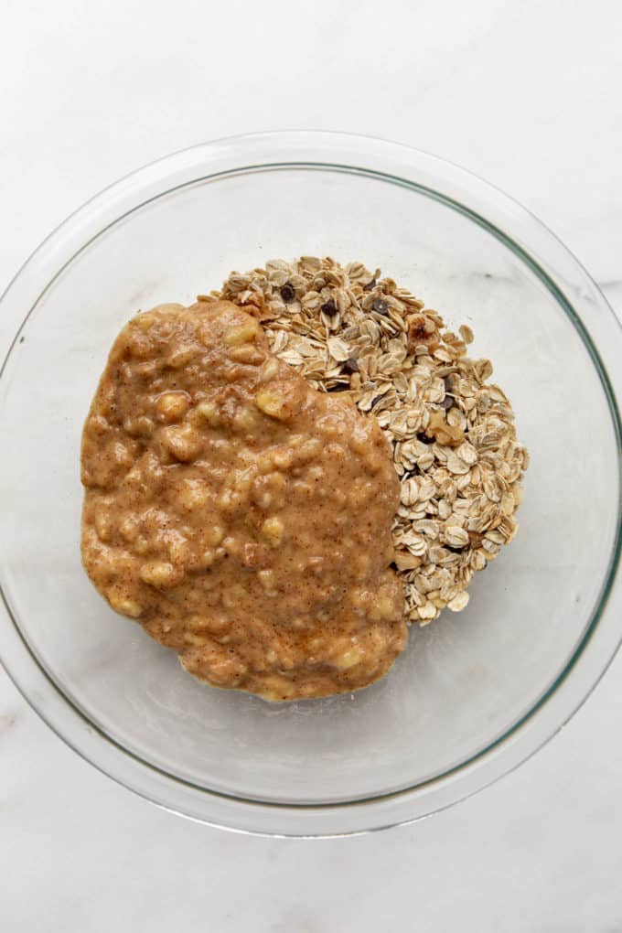 oats in a mixing bowl with mashed banana and almond butter