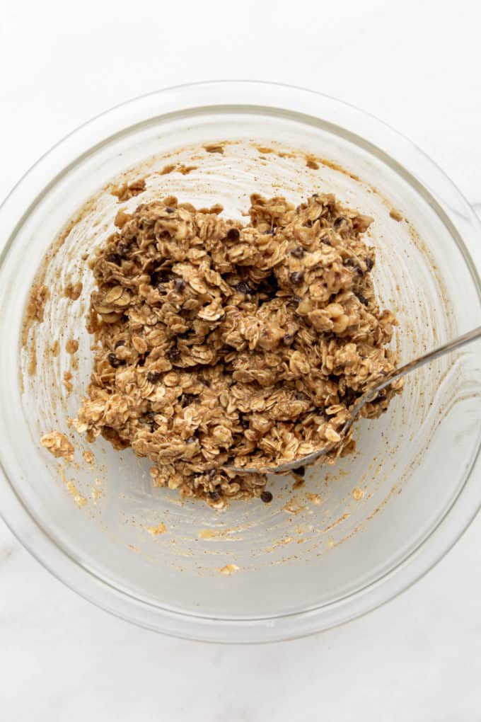 mixed up oats, chocolate chips, banana and almond butter in a clear mixing bowl