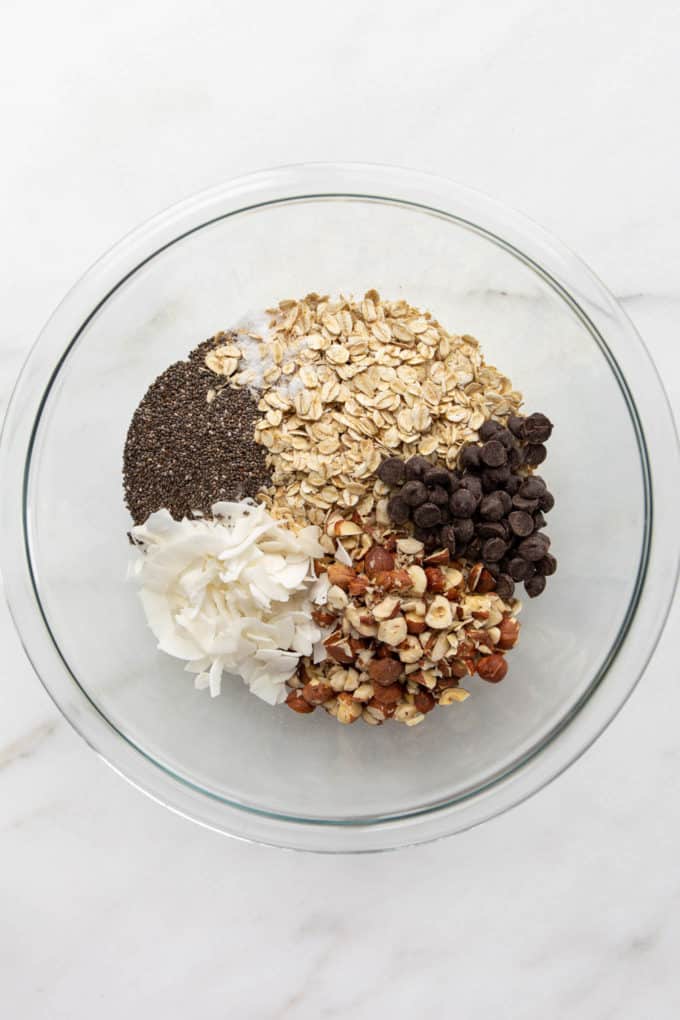 oats, chia seeds, coconut, hazelnuts and chocolate chips in a mixing bowl