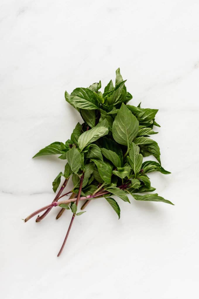 A bunch of Thai basil on a marble board