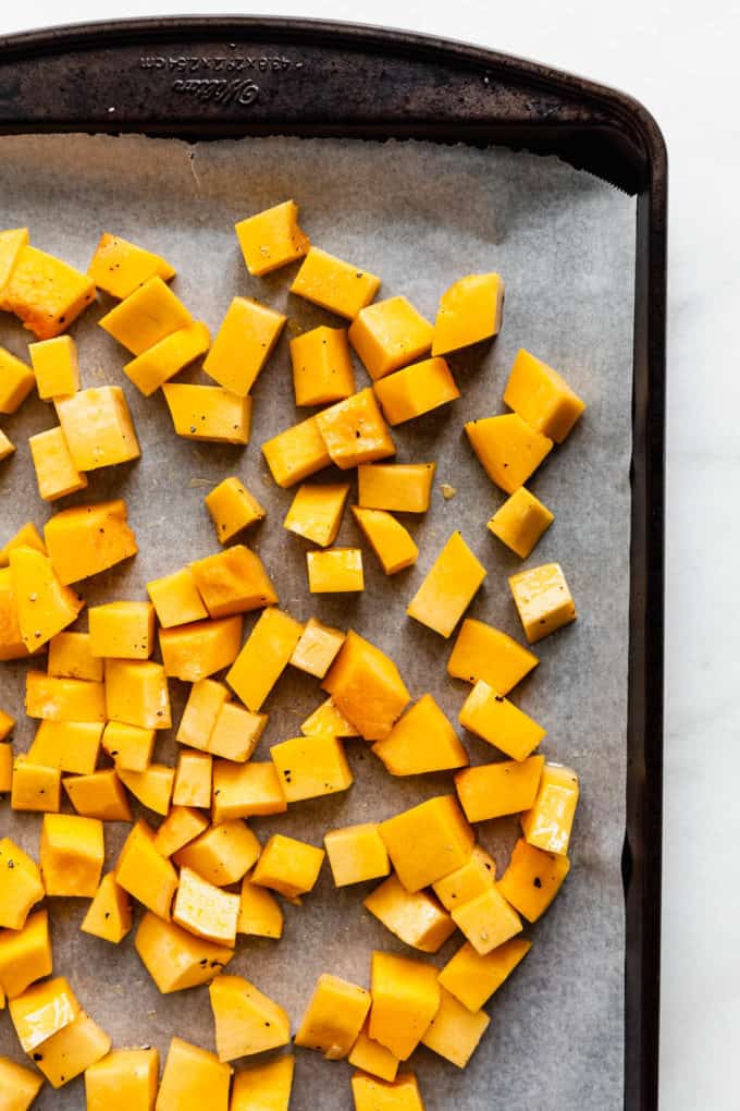 cubes of uncooked pumpkin on a baking sheet