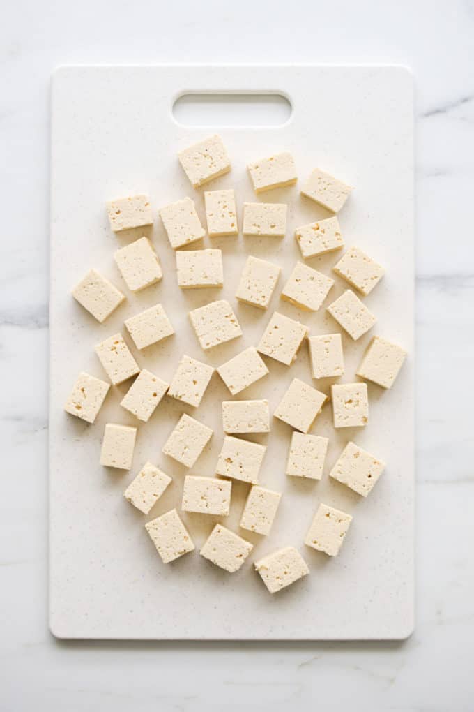 cubed tofu in a white cutting board