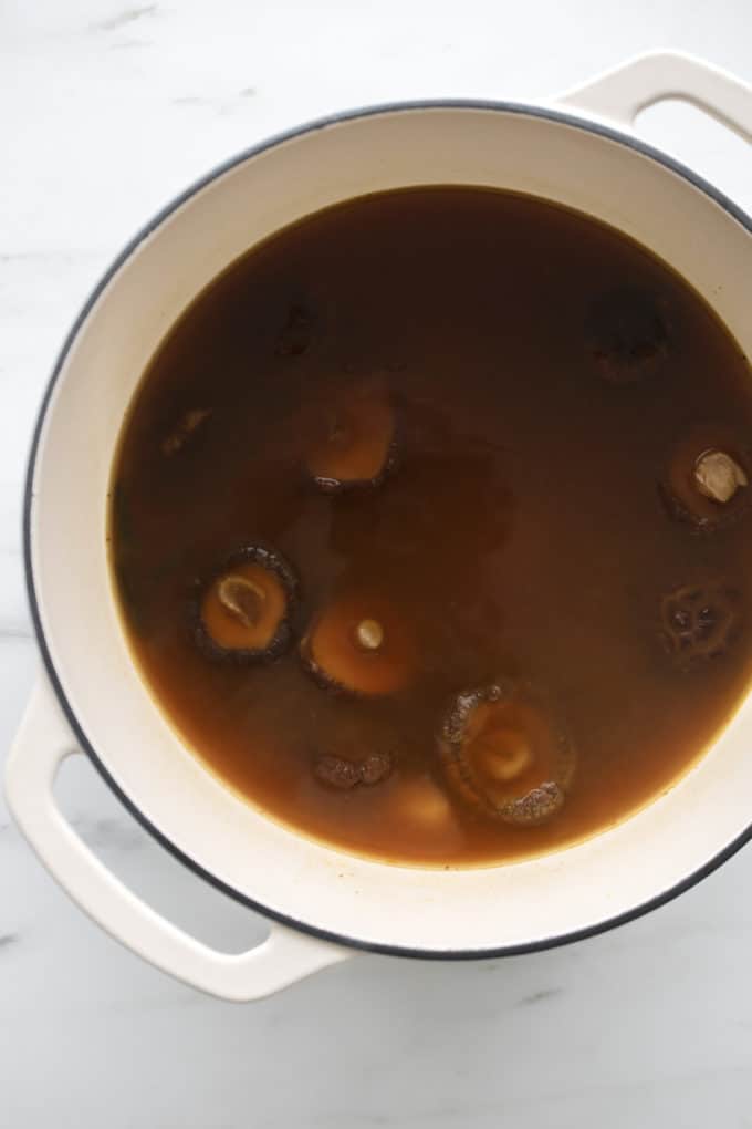 A white pot with vegan ramen broth in it