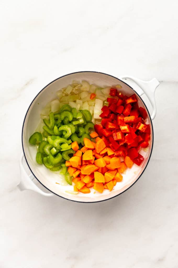 carrots, celery, carrots and onions in a white pot