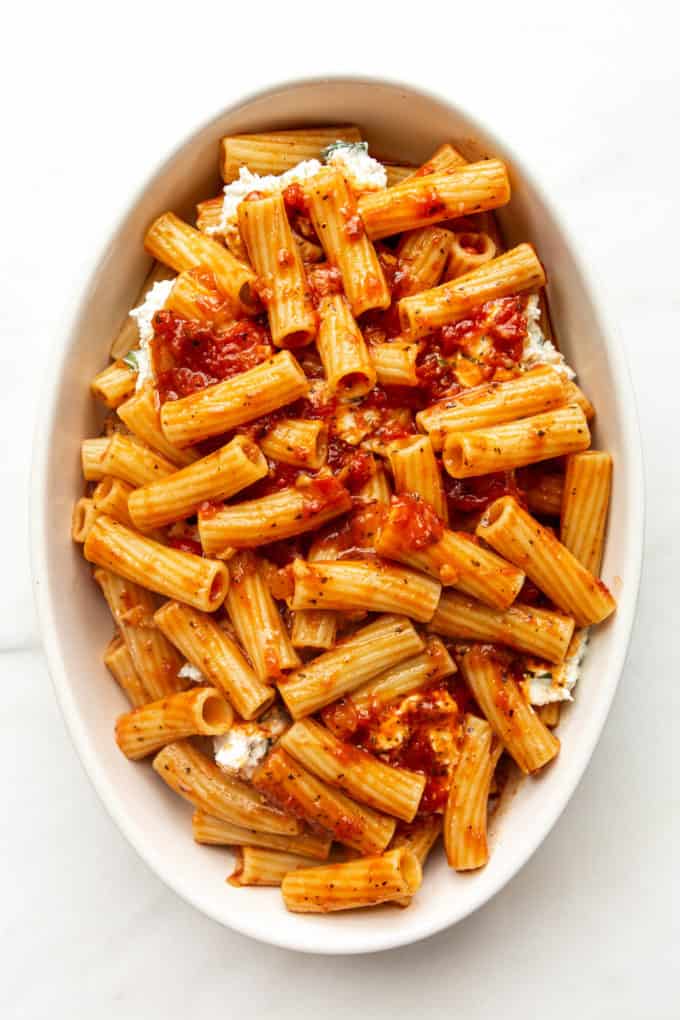 baked ziti noodles covered in sauce in a baking dish