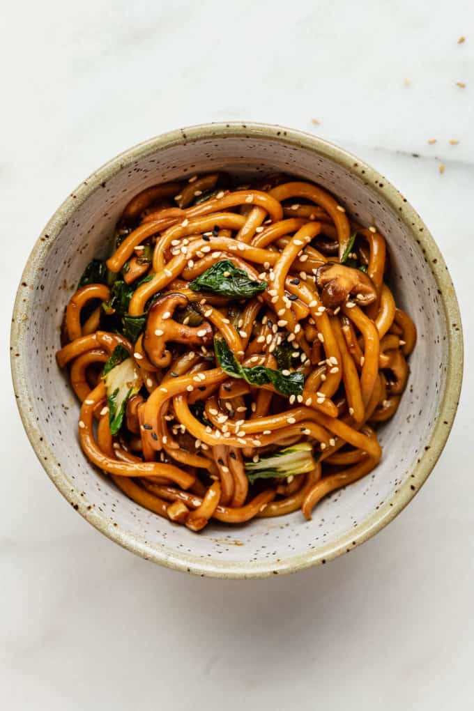 A bowl of yaki udon noodles topped with sesame seeds