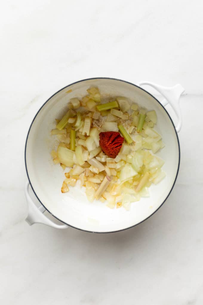 onions, garlic, lemongrass and curry paste in a white pot
