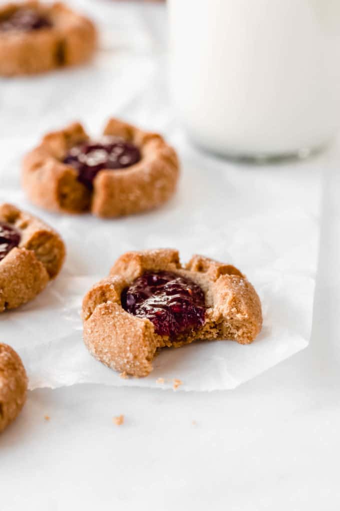 A peanut butter thumbprint cookie with a bite taken out of it