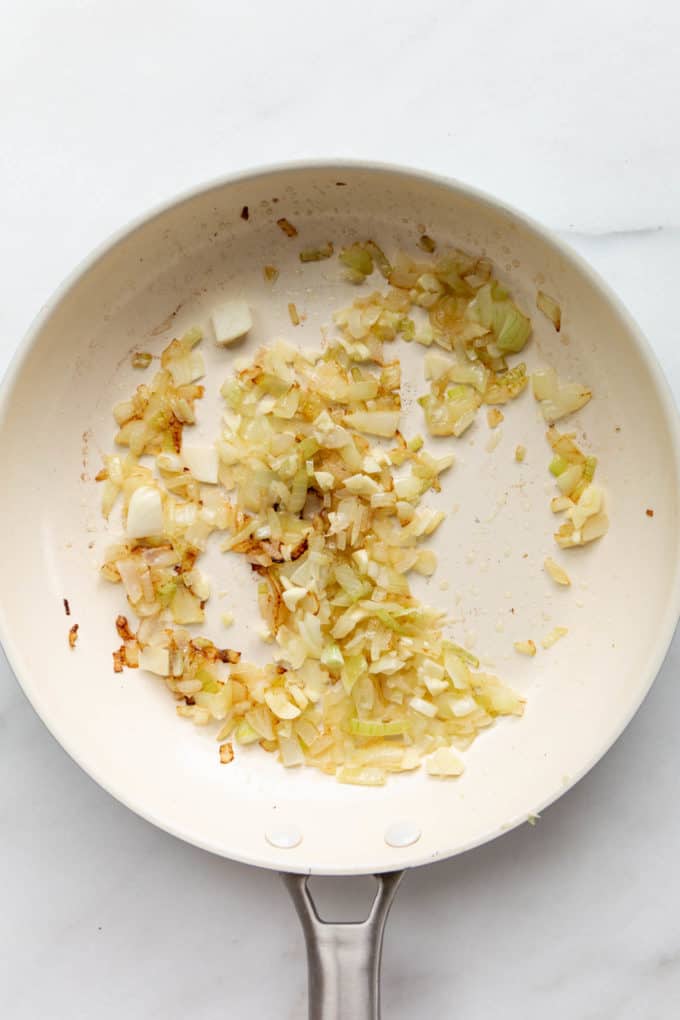 onions and garlic in a white pan