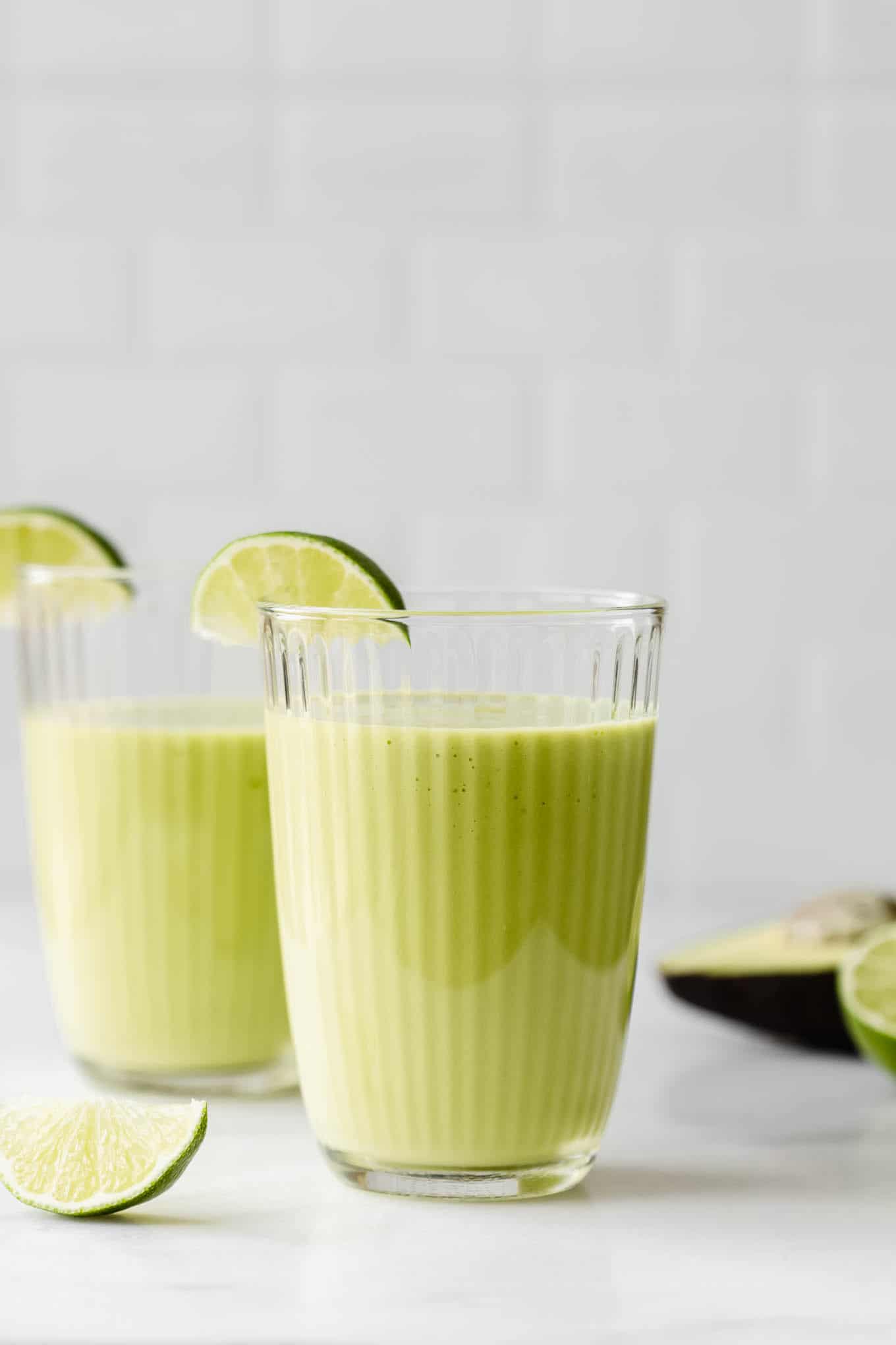 two avocado mango smoothies on a counter