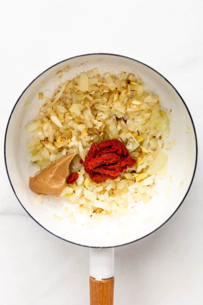 onions, garlic, curry paste and peanut butter in a white pot