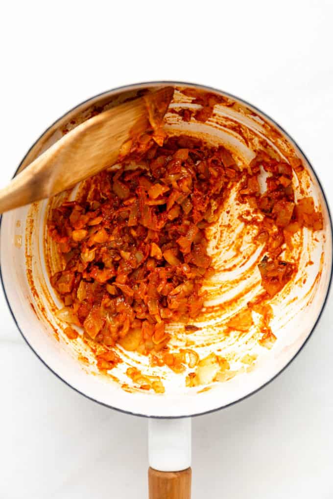 sauteéd curry paste and onions in a white pot