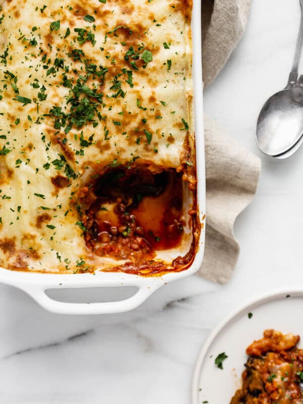 Vegan moussaka with a scoop taken out of it on a plate