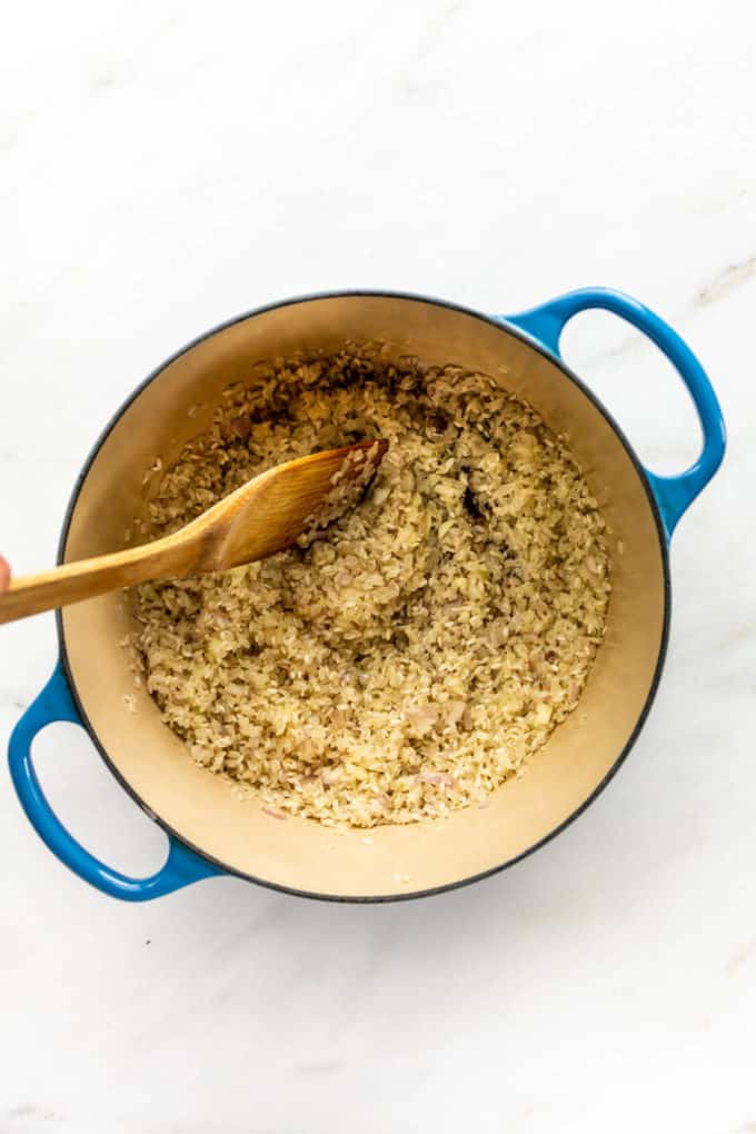 toasted arborio rice and shallots in a pot