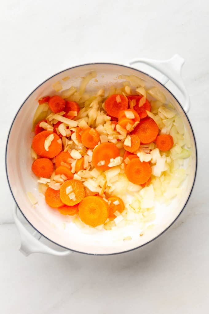 carrots and onions in a white pot
