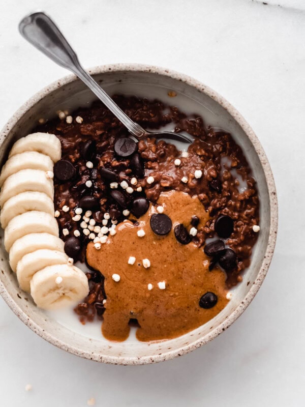 Chocolate oatmeal topped with chocolate chips, almond butter and sliced bananas