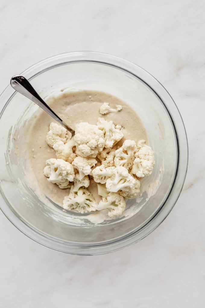 cauliflower florets in a mixing bowl with batter