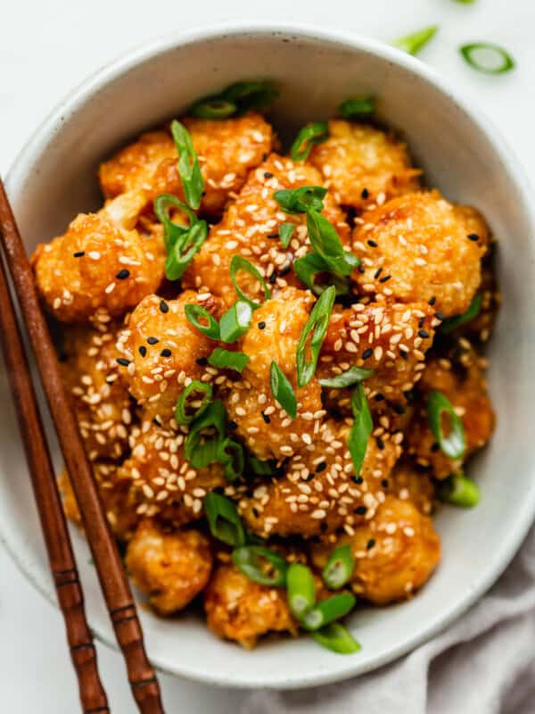 Orange cauliflower in a bowl with chopsticks on the side