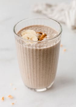 Peanut butter banana smoothie in a glass topped with banana