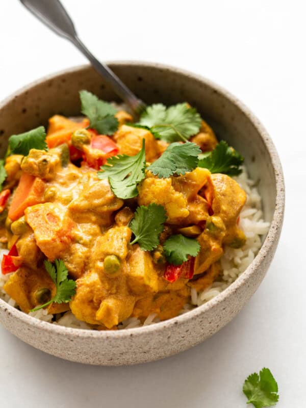 a bowl of vegetable korma topped with cilantro