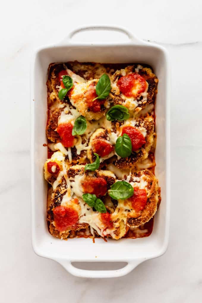 a white baking dish with cauliflower parmesan