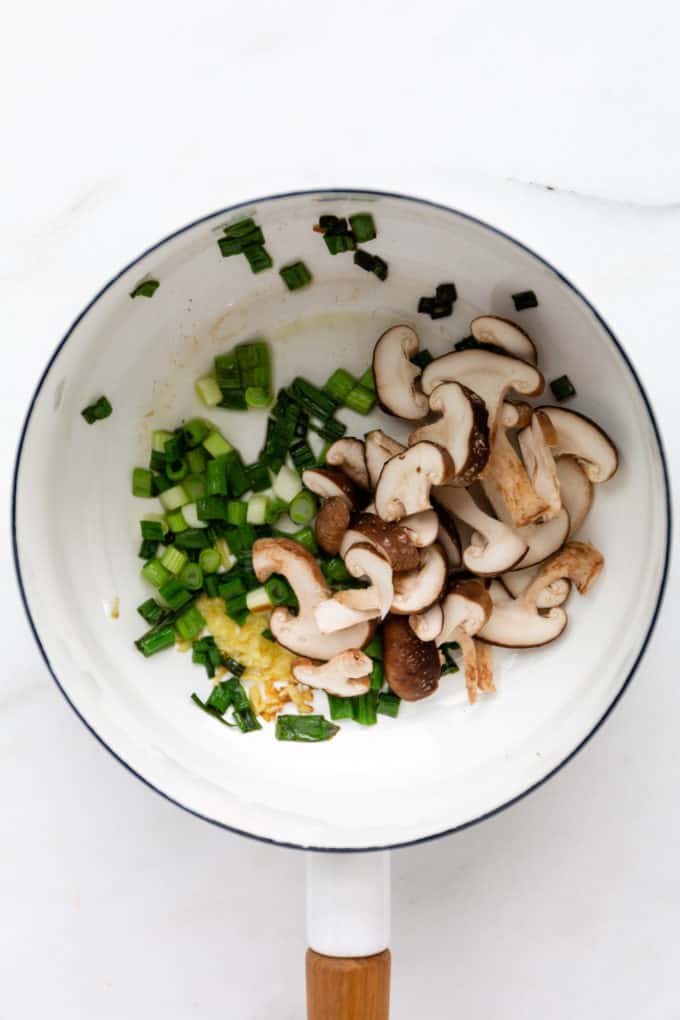 scallions, ginger and shitake mushrooms in a white pot